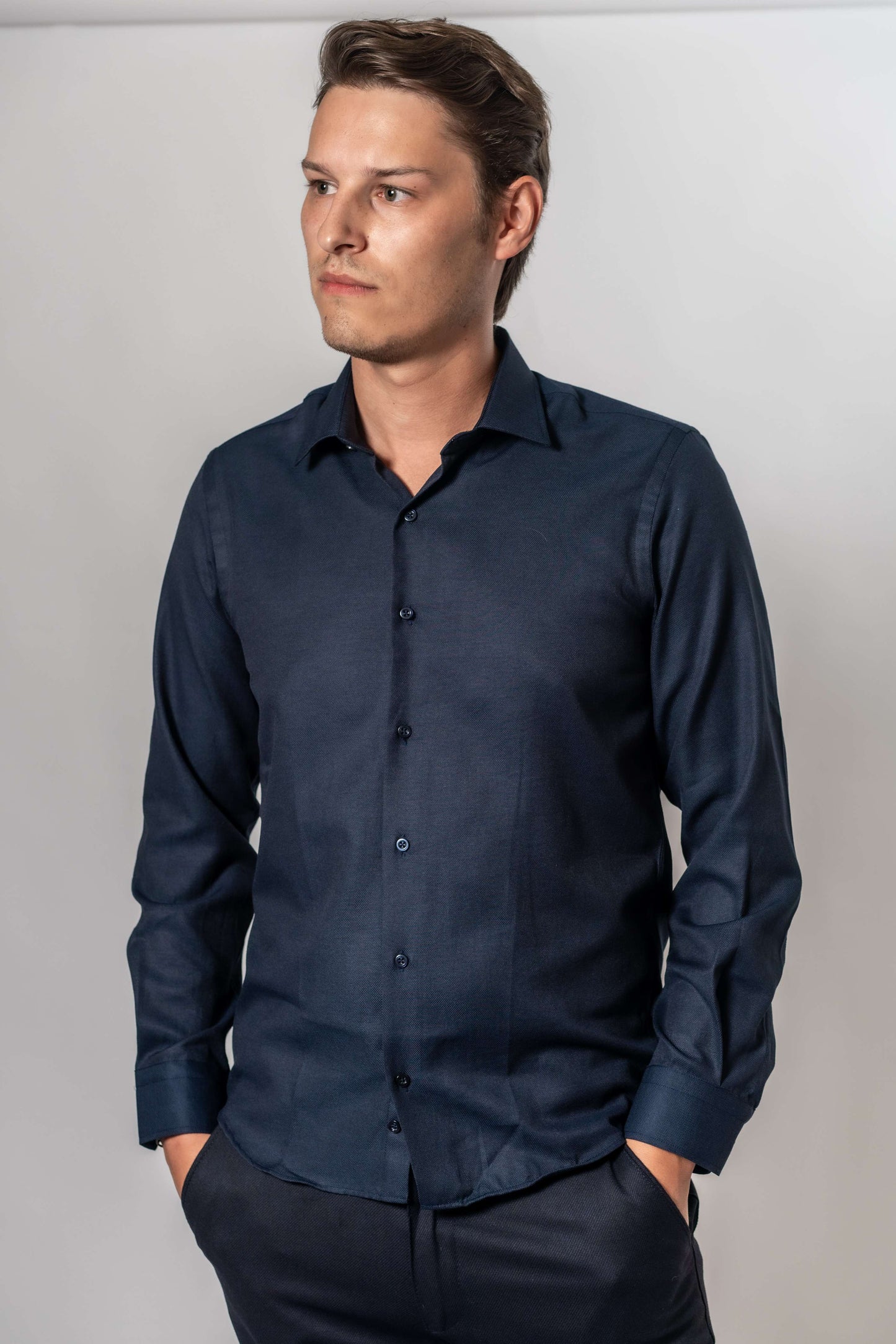 Man die donker blauw effen hemd van Suitify draagt