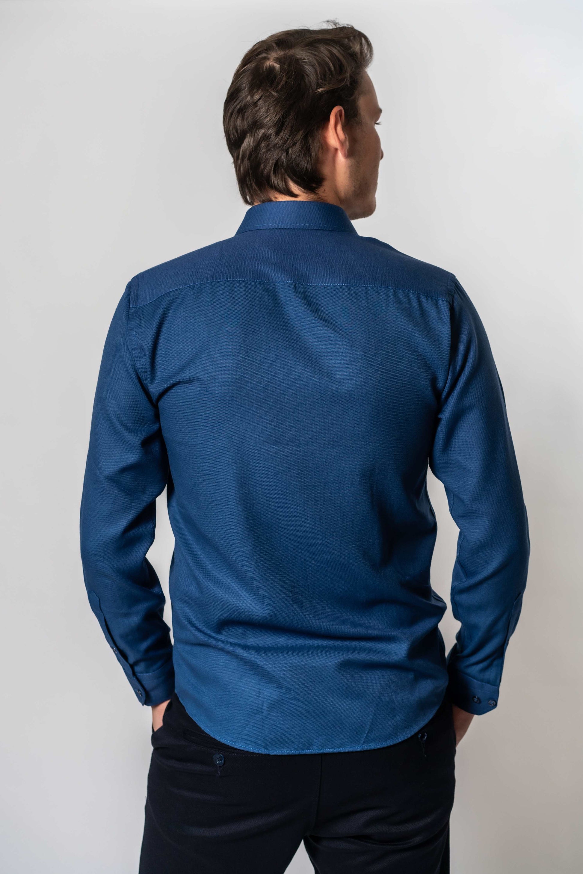 Achterkant van blauw effen hemd van Suitify gedragen door een man