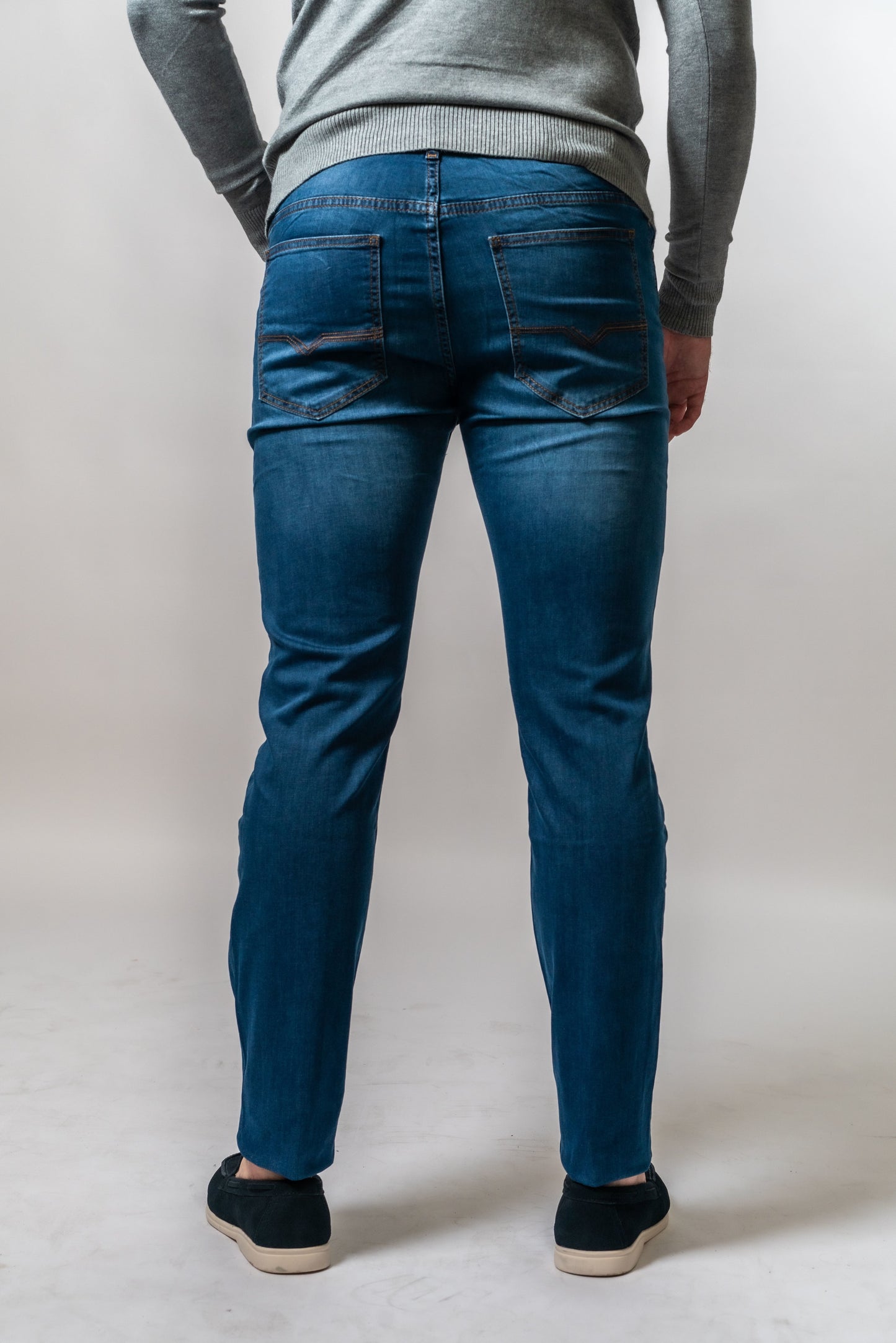 Achterkant van donkerblauwe jeans van Suitify gedragen door een man
