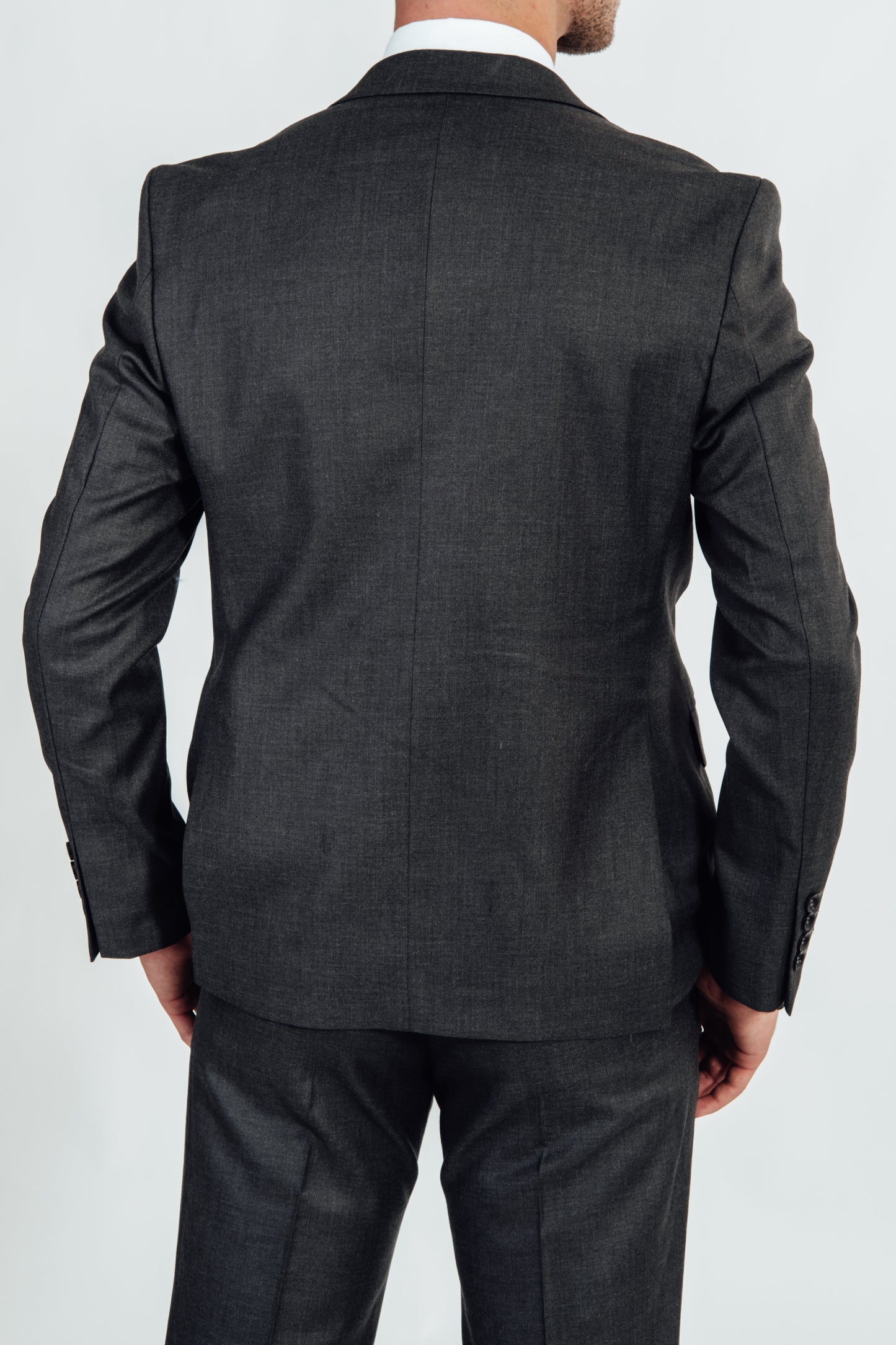 Achterkant van een grijs effen kostuumvest van Suitify gedragen door een man